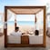 A couple enjoying drinks and relaxing in a cabana facing the ocean